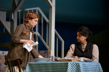 przy stole po prawej starsza kobieta Maryla starsza kobieta zdenerwowana po prawej Ania młoda dziewczyna z rudą peruką ma ścierkę w ręce