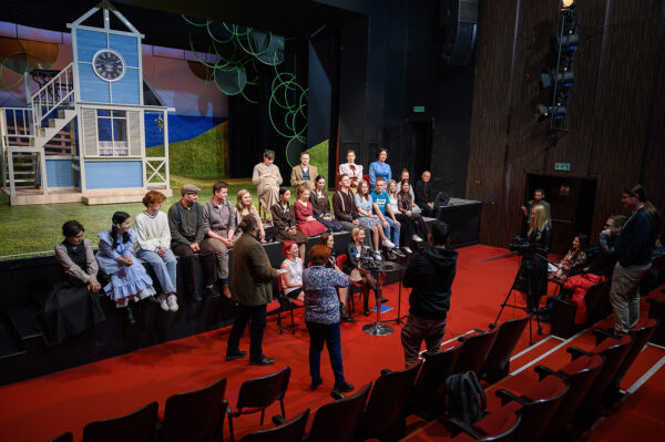 Zdjęcie konferencji prasowej, na scenie siedzi kilkunastu aktorów, naprzeciw nich na widowni siedzą dziennikarze