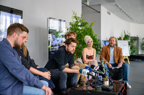 konferencja prasowa, czterech mężczyzn i dwie kobiety siedzą przed nimi stolik z kilkoma mikrofonami. są to aktorzy i dyrektor teatru